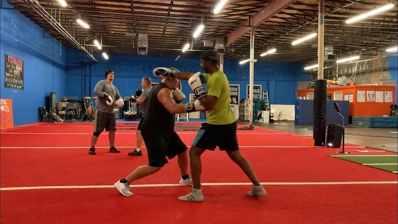 Members sparring with pads in a boxing class